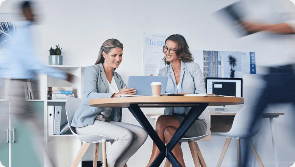 2 people having a meeting at a desk