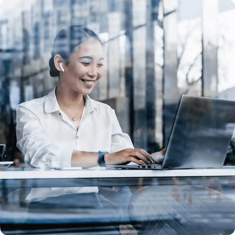 Female IT professional smiling while working on laptop